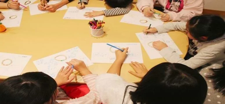 輪になって絵を描いている